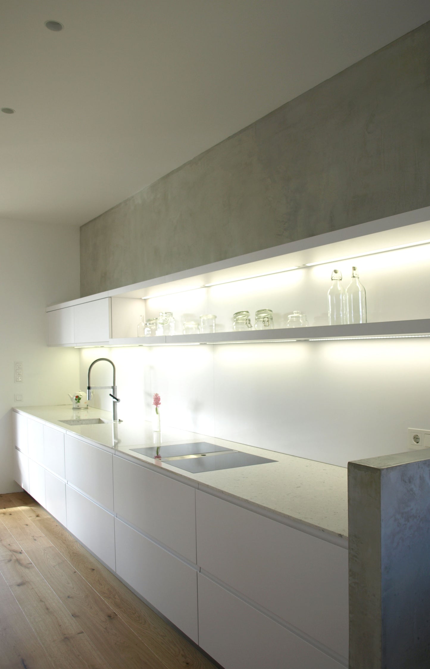 Moderne Küche mit integriertem Lichtsystem und minimalistischer Gestaltung, eingebettet in einem Einfamilienhaus mit zeitgemäßer Architektur.