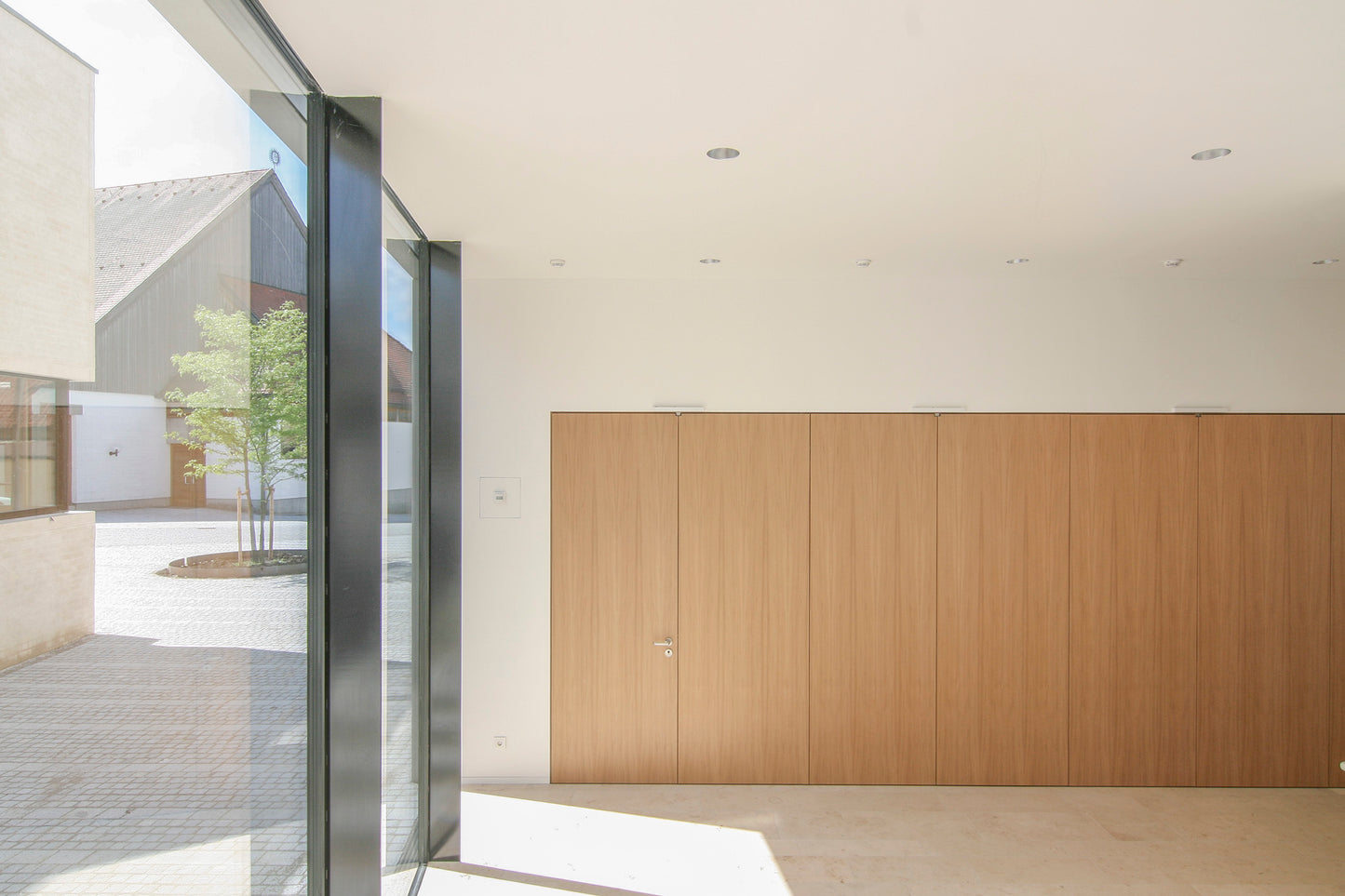 Foyer des Saalgebäudes in Wettstetten mit flächigen Türelementen und Freitreppe.