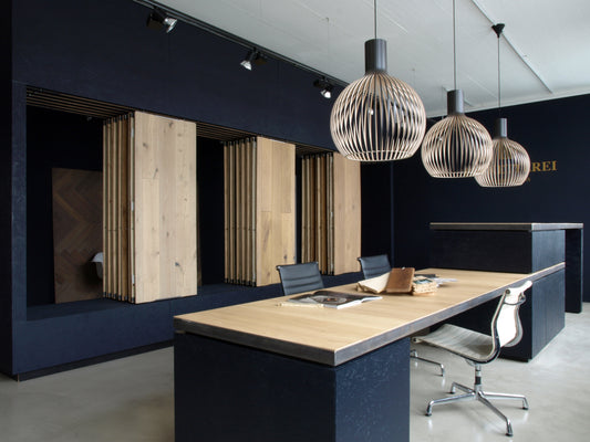 Gesamtraumansicht eines Parkett-Showrooms mit klaren Linien, eleganter Beleuchtung und interaktiven Präsentationsflächen.